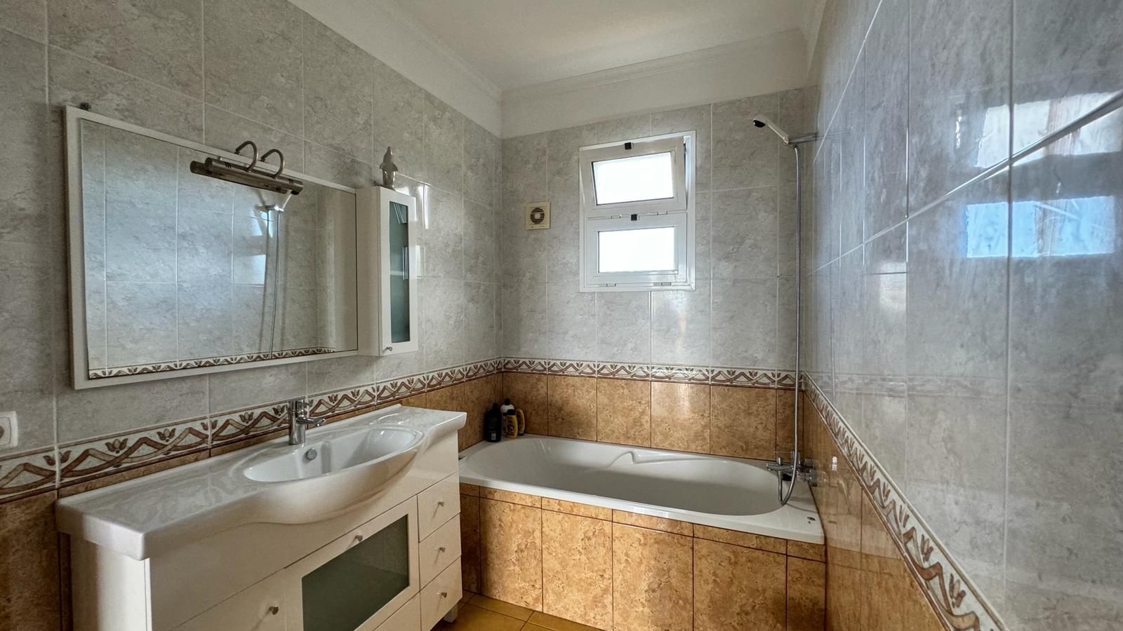 Une salle de bain équipée d’un lavabo, d’un meuble-lavabo, d’une baignoire et d’une douche.