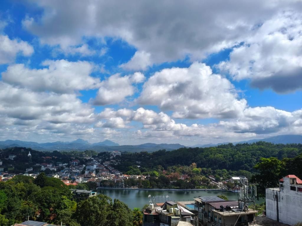 A cityscape with a river, buildings, and mountains in the background.