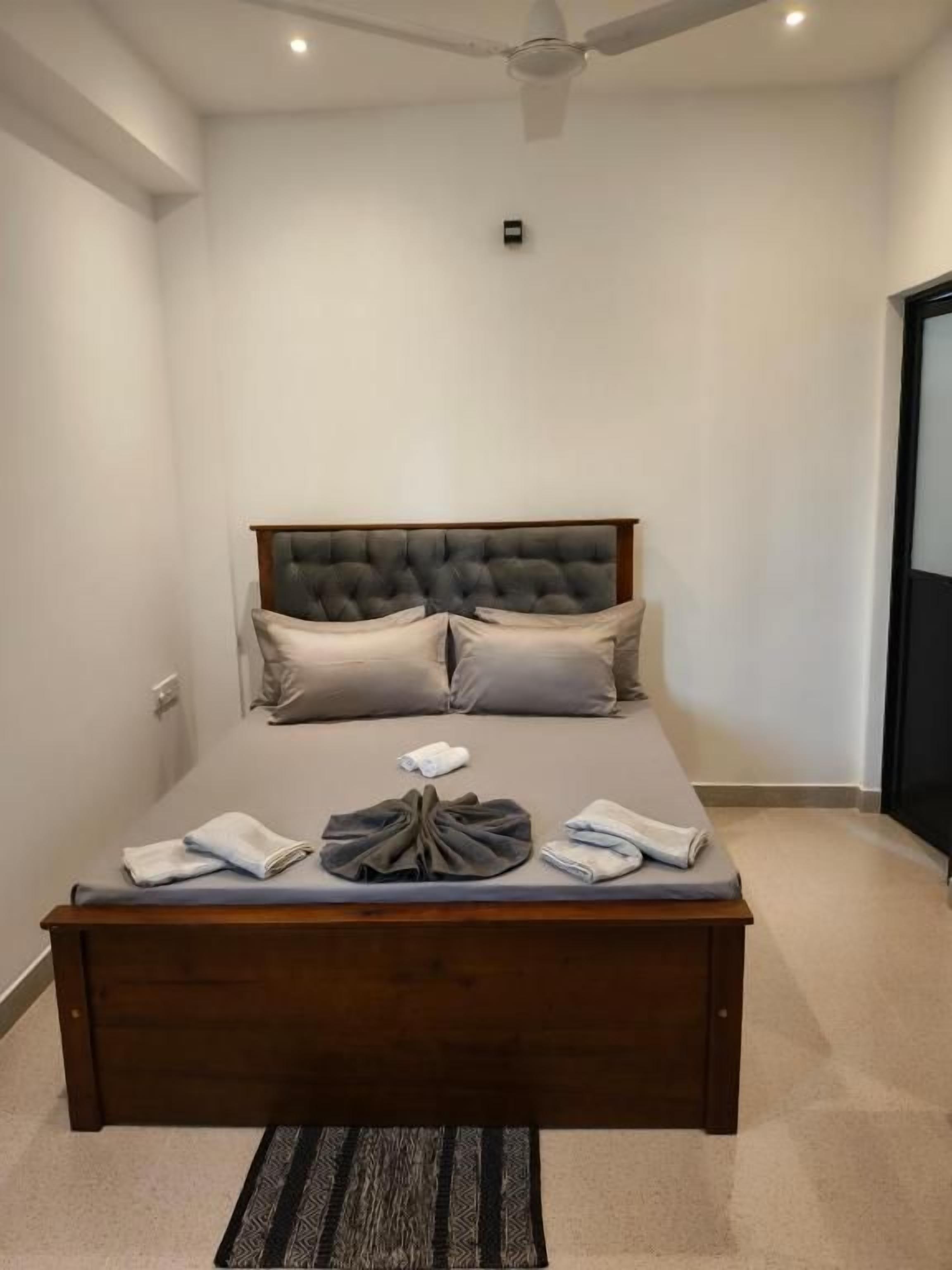 A bedroom with a large bed, a ceiling fan, and a carpeted floor.