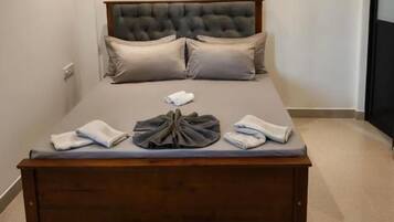 A bedroom with a large bed, a ceiling fan, and a carpeted floor.