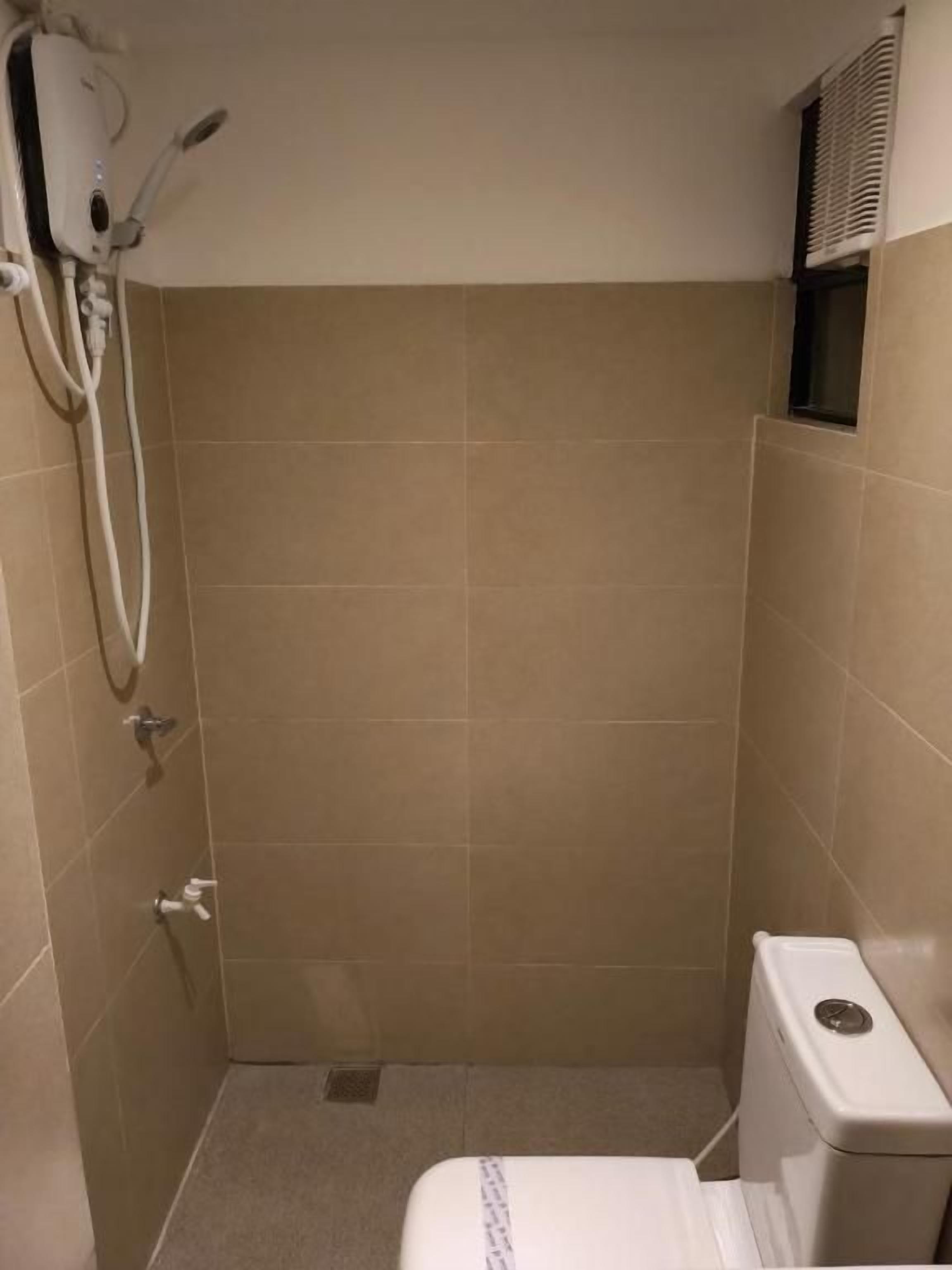 Ein kleiner, abgeschlossener Duschbereich mit Toilette und Handtuchhalter.