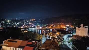 A nighttime view of a city with a river, buildings, and a bridge.