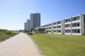 A pathway leading to a modern building complex with multiple floors and balconies. - 2 Raum Appartement im IFA Fehmarn mit Balkon (Fehmarn)