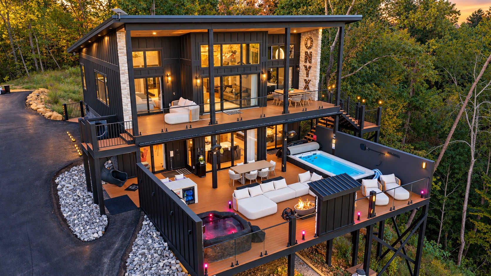 A two-story modern house with a large deck, outdoor seating, and a hot tub.
