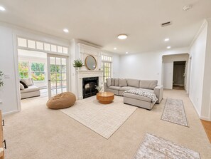 A spacious living room with a fireplace, a sofa, a bean bag, and a coffee table. - Shirley Mansion - Family Stay, 3BR/2.5BA One-Level, Office, Sunroom, Yard (Shirley)