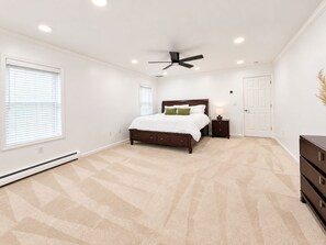 A bedroom with a bed, a nightstand, a ceiling fan, and a dresser. - Shirley Mansion - Family Stay, 3BR/2.5BA One-Level, Office, Sunroom, Yard (Shirley)