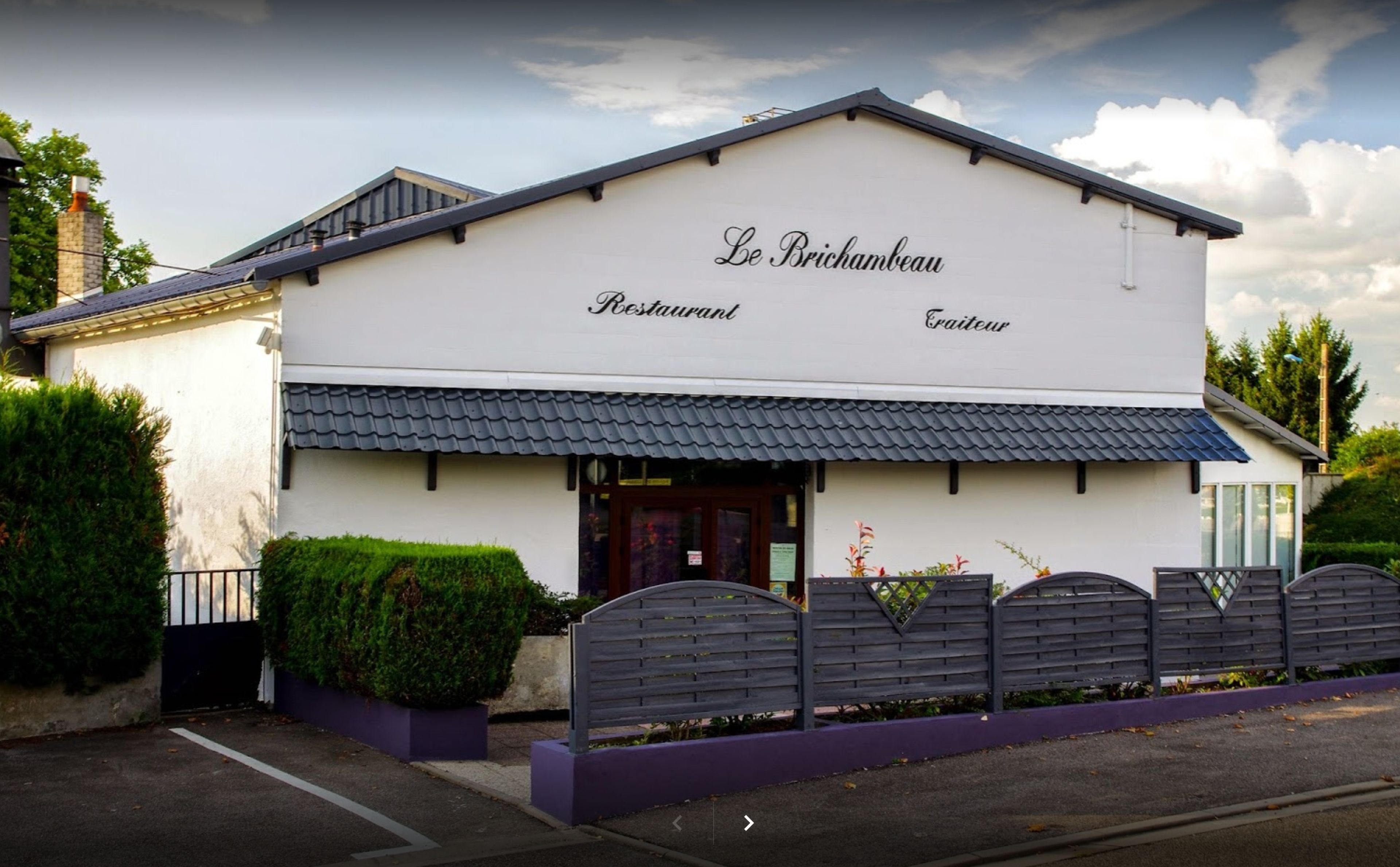 A two-story building with a sign that reads 'Le Brichambeu Restaurant' and 'Eau de Table.'