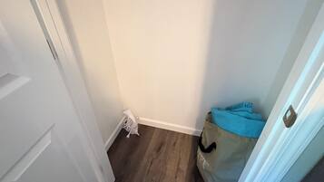 A hallway with a white door, a blue bag, and a white object on the floor.