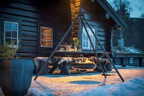 En hytte med pejs og et vindue, der viser udsigt til omgivelserne.