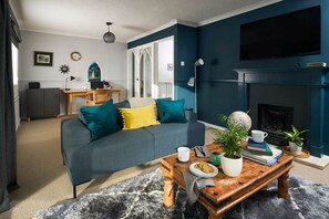 Ein Wohnzimmer mit Sofa, Couchtisch und Kamin.