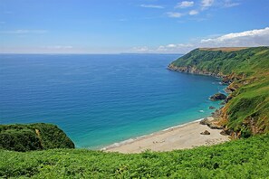 Eine Küstenlandschaft mit Strand und Klippen.
