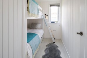 A room with a bunk bed, a ladder, a window, and a rug. - Skylark Beach House - sleeps 6 guests  in 3 bedrooms (Hayle)