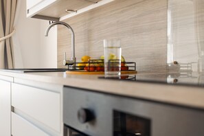 A kitchen with a modern faucet, a fruit bowl, and a clear glass. - Starfish Studio Apartment - sleeps 2 guests  in 1 bedroom (Falmouth)