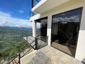 Un bâtiment moderne doté d’un balcon donnant sur un paysage montagneux.