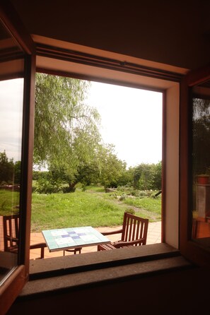 A room with a large window, a wooden table, and a chair. - Vrbo Property (Carruba-San Leonardello)