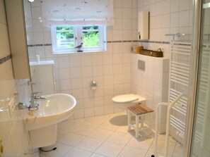 A bathroom with a white sink, toilet, and a small wooden stool. - Holiday Home With 1 Bedroom (Wyk auf Foehr)
