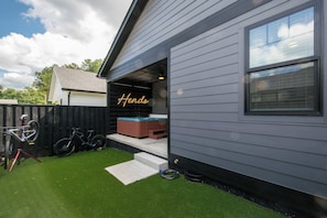 Ein Wohnhaus mit Garage, einem Fahrrad und einem Whirlpool.