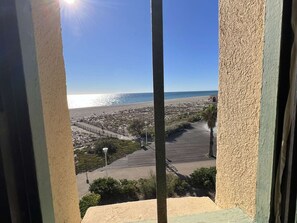 A coastal view from a balcony with a clear sky, a beach, and a small building. - Duplex with panoramic view - 4 guests (Port Leucate)