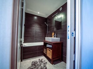Ein modernes Badezimmer mit Badewanne, Waschbecken und Spiegel.