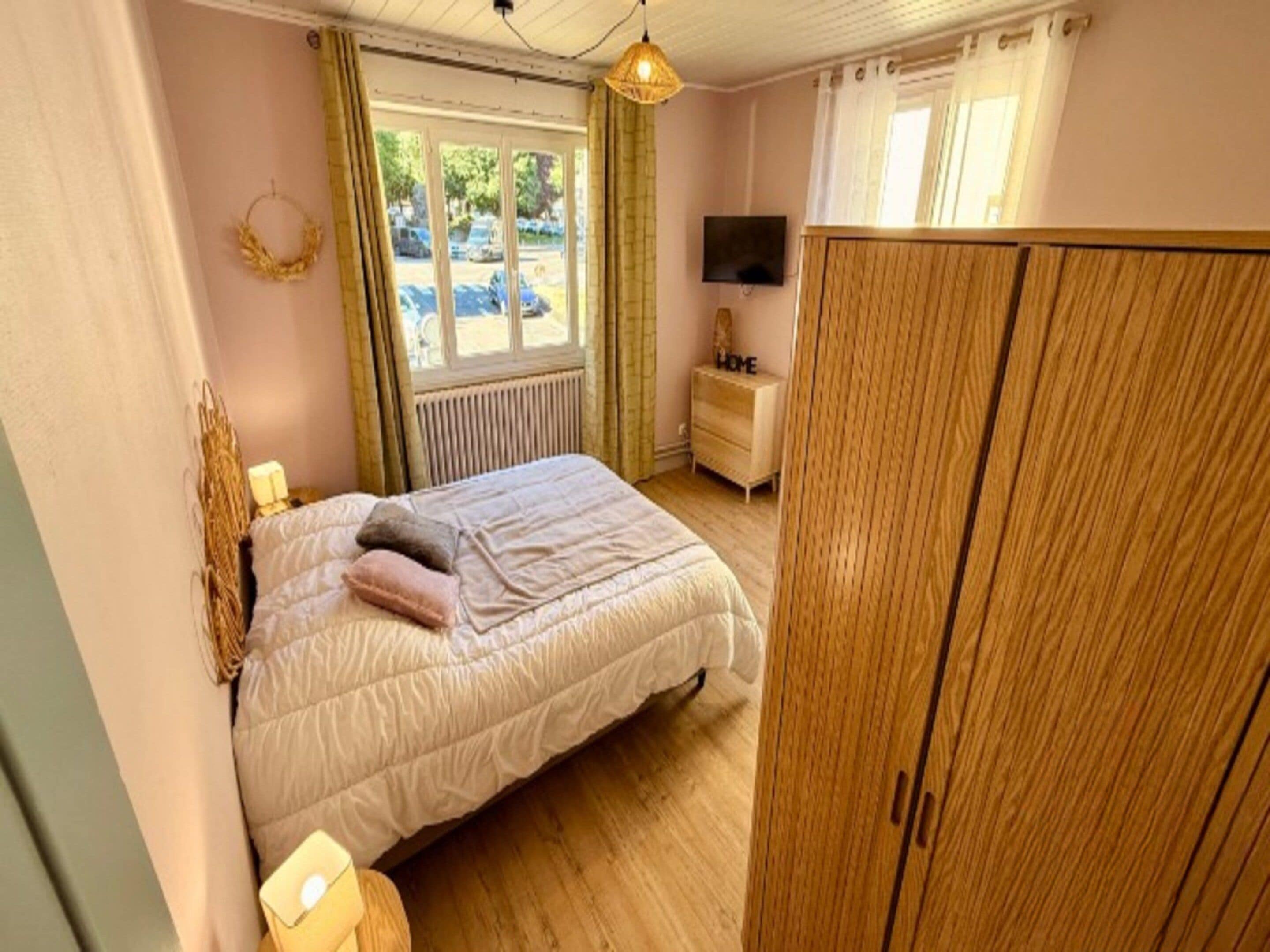 Une chambre à coucher comprenant un lit, une commode, un téléviseur et une armoire.