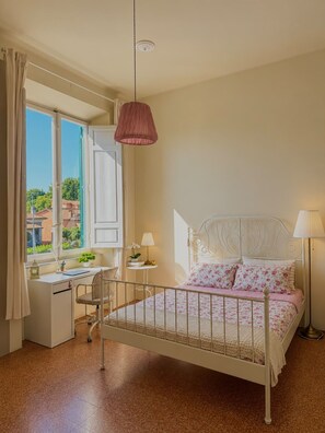 A bedroom with a bed, desk, chair, and a window with curtains. - 34a strada 1-bedroom  with AC in charming Lucca (Lucca)