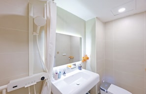 Un baño moderno con un lavamanos blanco, un espejo y una ducha.