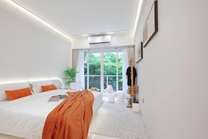 Un dormitorio moderno con una cama grande, vistas a la vegetación y un diseño minimalista.