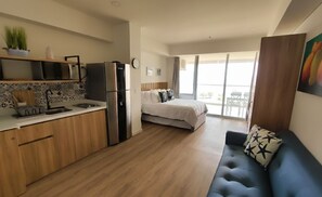 A modern apartment with a kitchenette, a bedroom with a bed and a balcony, and a living area with a sofa. - Comfortable suite with sea view | 2 minutes to airport | Pool, sauna, and more (Cartagena de Indias)