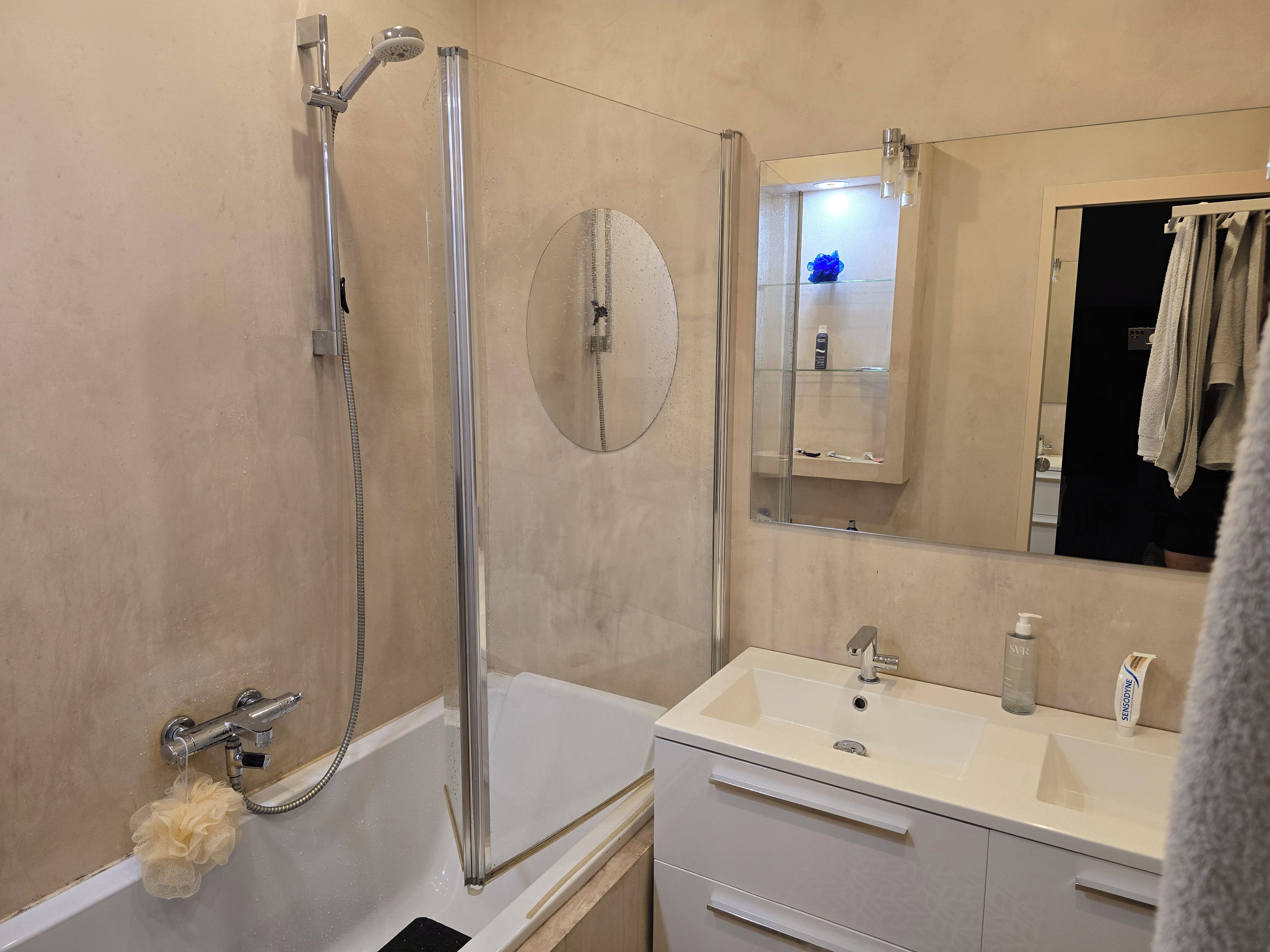 Ein Badezimmer mit einer Badewanne, einer Dusche, einem Waschbecken und einem Spiegel.