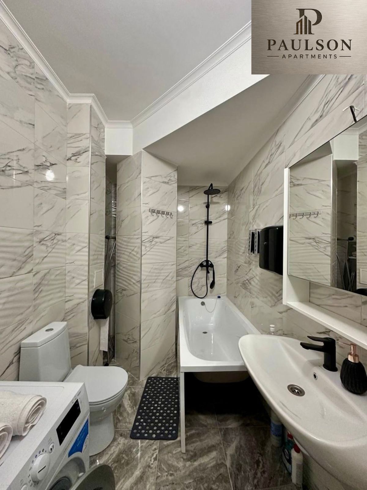 A bathroom with a toilet, a shower, and a sink.