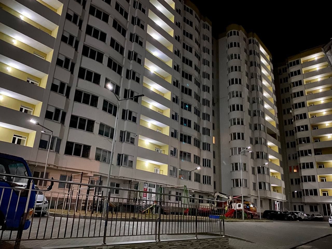 A multi-story building with balconies and a gated entrance.
