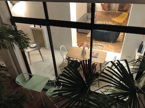 Una habitación con una mesa de comedor, sillas y una planta en maceta.