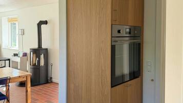A kitchen with a built-in oven and a wood-paneled cabinet.