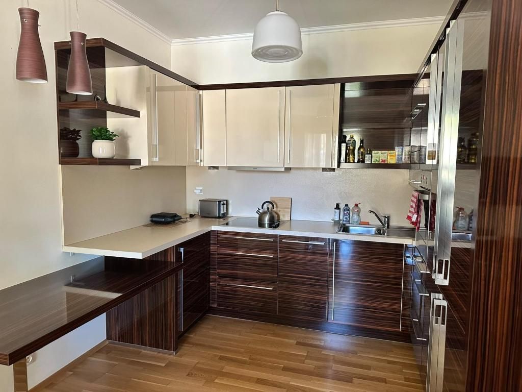 A modern kitchen with wooden cabinets, a countertop, and a built-in oven.