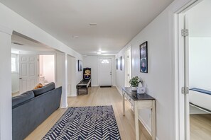 En moderne gang med sofa, billardbord og konsolbord med en potteplante.