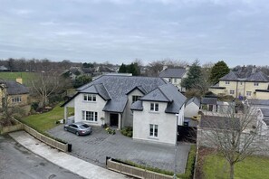 A two-story house with a paved driveway and a car parked in the driveway. - Located in the heart of Adare village, 150yards from Ryder Cup Adare Manor (Adare)