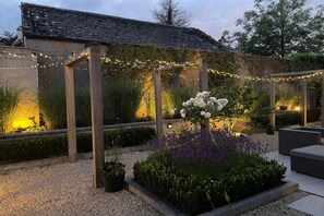 A garden with a pergola, string lights, and a flower arrangement. - Located in the heart of Adare village, 150yards from Ryder Cup Adare Manor (Adare)