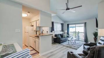 A modern apartment with a kitchen, dining area, and living room.