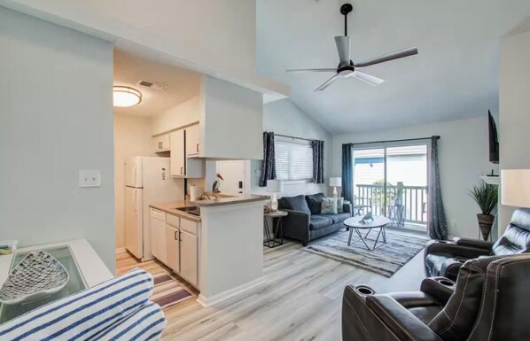 A modern apartment with a kitchen, dining area, and living room. - Palms Escape (Galveston)
