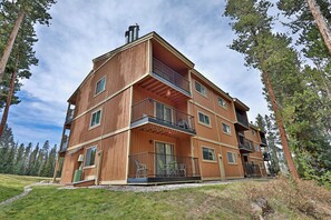 Ein mehrstöckiges Holzhaus mit Balkonen, umgeben von Bäumen.
