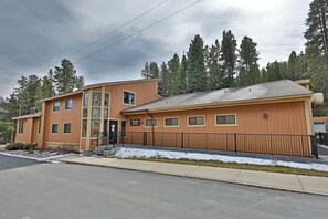 A multi-story building with a wooden facade, a visible entrance, and a sign indicating it is a lodge. - Cozy Winter Park Condo in Forest + Walk to Town! (Winter Park)