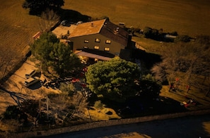 An aerial view of a two-story house with a sloped roof, surrounded by a well-maintained lawn and a few trees. - La Casona de Tamaya (Tamajón)