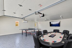 A conference room with a ping pong table, a television, and a poker table with chips. - Charming MidTown Tulsa Home, w/Game Room,Walking Distance to Tulsa Expo Center (Tulsa)