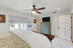 A bedroom with a bed, a ceiling fan, a television, a dresser, and a door. - Charming MidTown Tulsa Home, w/Game Room,Walking Distance to Tulsa Expo Center (Tulsa)
