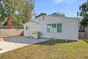 A single-story house with a detached garage, a small patio area, and a wooden fence. - Charming MidTown Tulsa Home, w/Game Room,Walking Distance to Tulsa Expo Center (Tulsa)