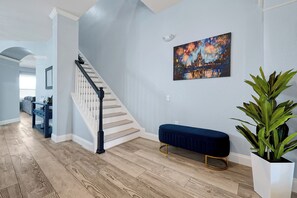 Ein modernes Interieur mit einer Holztreppe, einer Bank und einem Wandbild.