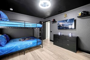Habitació amb literes, escriptori, televisió i objectes de decoració de Star Wars.