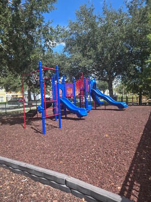 A playground with a slide and climbing structures. - Family Fun Getaway in Kissimmee! 4-Bedroom Retreat (Kissimmee)
