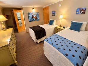 A hotel room with two beds, a dresser, a mirror, and artwork on the walls. - The Wiley | Stylish Stay in the Heart of Vermont (Peru)