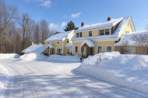 A two-story house with a snow-covered driveway and a mailbox. - Wiley Inn | Stylish Stay in the Heart of Vermont (Peru)